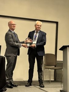 A picture of Doug Lawrance accepting the Distinguished Service Award from Dr. Charles Gardner, 2023-24 President of alPHa
